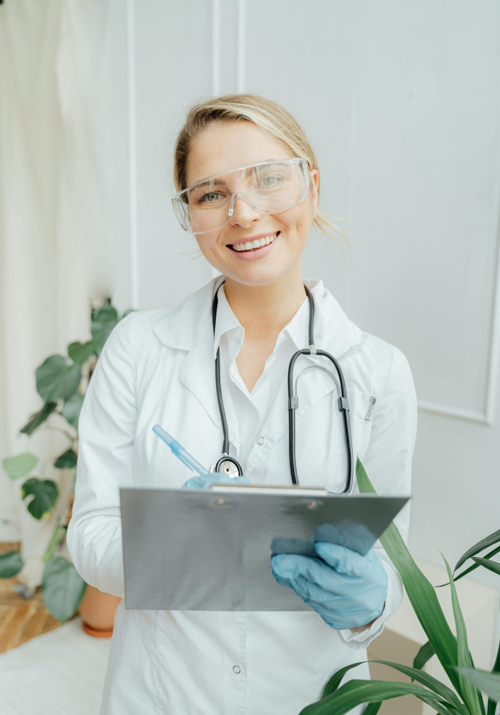 Confident female doctor with clipboard in a bright medical office.